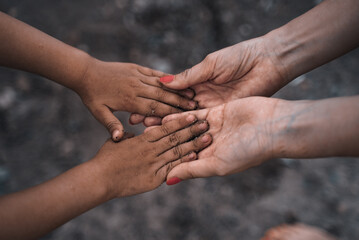 The girl holds in her hands the hands of a child. International family. Help to refugees. Social problems of Racism, emigrants, Anti-Racism
