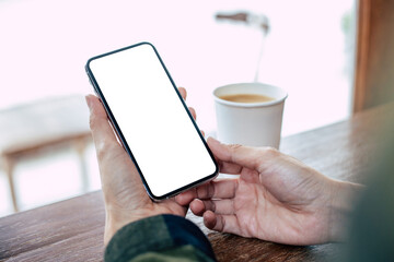cell phone mockup image blank white screen.woman hand holding texting using mobile on desk at coffee shop.background empty space for advertise.work people contact marketing business,technology