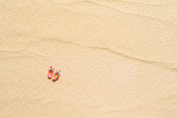 One pair of flip flops on a sandy beach. Aerial view.