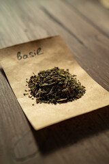 Heap of dry basil on craft paper sheet. Aromatic spice.