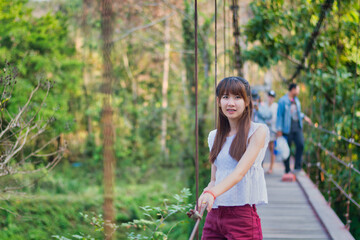 Asian woman travelers sitting on the bridge waterfall at Namtok Kaew Chan waterfall, Ratchaburi, Thailand..