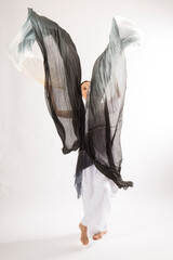 Adult woman dancing with long, swirling,black and white fabric.