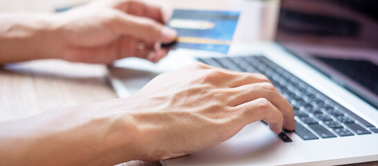 man holding credit card and using laptop via web, business freelancer working at home office. business, lifestyle, technology, ecommerce, digital banking, online payment and shopping concepts
