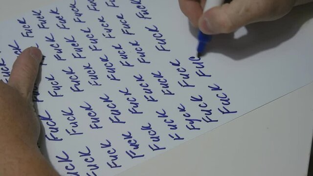the hand of a man writes a letter on a white sheet of A4 format in which there is only one word Fuck. 4K