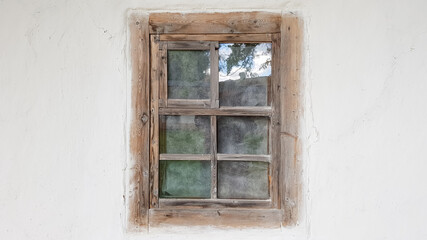 Old window in a vintage traditional peasant house in Ukraine. Antique wooden window frame. Pirogovo National Museum in the open air in Kiev. Copy space.