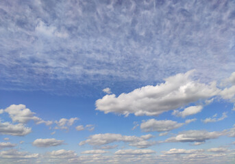 Blue sky with clouds of various shapes.