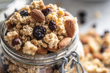 Jar of muesli with nuts, almonds grapes and dried fruits - closeup