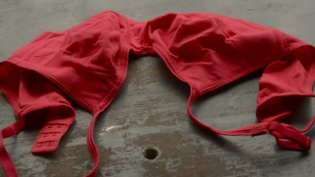Red bra on rustic metallic floor. Romantic passion female lingerie. Sexy fashion background. Still life video footage.