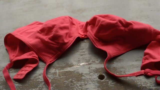 Red bra on rustic metallic floor. Romantic passion female lingerie. Sexy fashion background. Still life video footage.