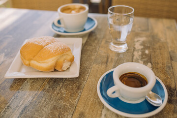 Coffee and croissant on vacation. Breakfast on summer terrace.