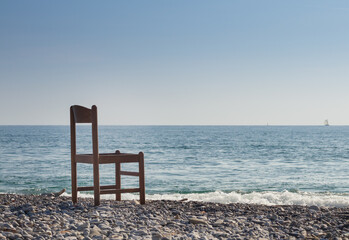 A wood chair abandoned on the beach