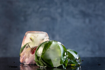 a composition of peony flowers frozen in ice on a dark background, a creative summer concept....