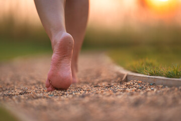 barefoot girl walking on the walkway ground stone with sunset light shine