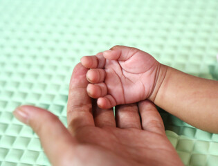 mother hand holding her baby hand

