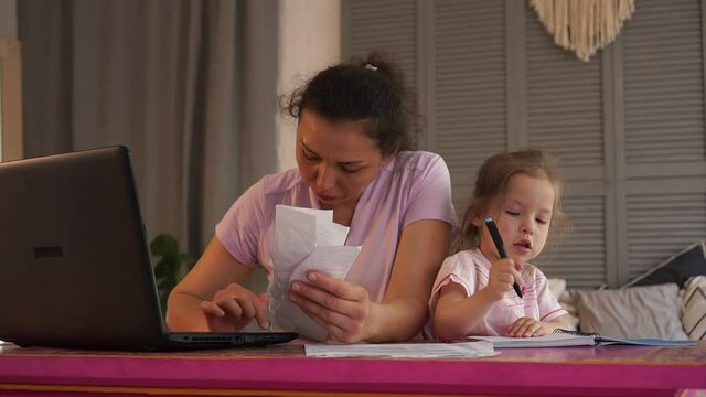 Covid-19 &ndash; supporting single parent families through the crisis. Worry mother calculating their domestic budget at home