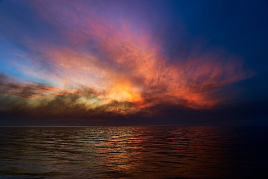 Sea sunset. Smoke wildfires sweeping across the sky.