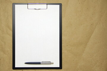 A tablet with a white sheet of A4 format on a beige craft paper.