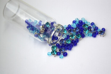 Bisser, stones for needlework and clothing decor. Small beads of blue color on a white background.