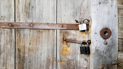 Old vintage metal padlock on a closed wooden door of an old farmhouse. The true style of the village. close-up. focus on the castle. Wooden background, texture. Copy space