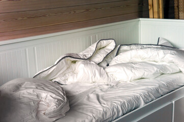 Unmade bed and crumpled bedding