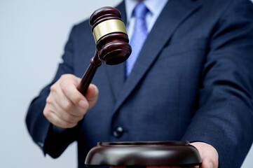 Male businessman holding a gavel in hand. justice and auction concept.