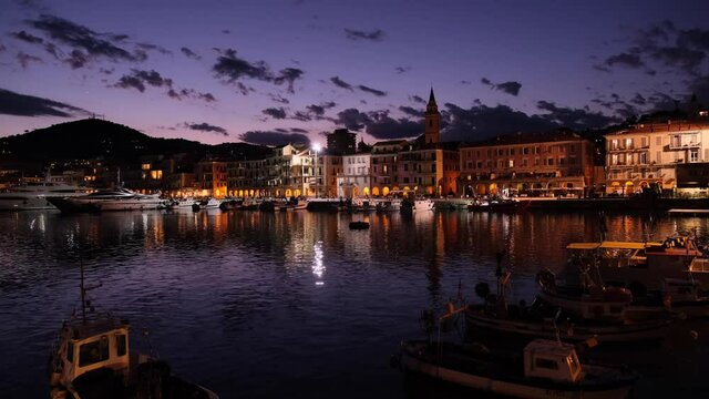 Cityscape of Imperia in Liguria. Port urban city at night. Boats and yacht in harbor. Travel destinations, transport, nautical.
