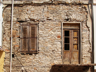 Abandoned and ruined house, a window and the door, Symi island, Greece
