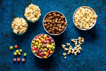 Flavored popcorn on blue desk from above