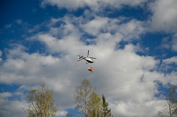 helicopter flying with manure over a forest