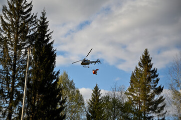 Fototapeta na wymiar helicopter flying with manure over a forest
