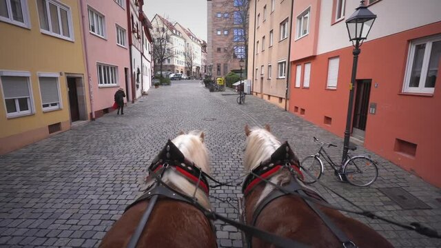 POV stagecoach is pulled by two horses through old street - carriage ride - Nuremberg, Germany