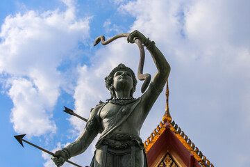 Statue in Bangkok, Thailand of the god Vishnu holding the bow Sharing