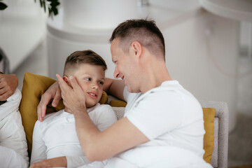 Dad and son are cuddling. Father and son sharing love at home.