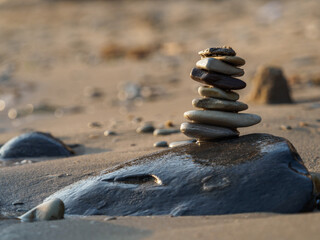 Balance of stones on a large stone near the sand.