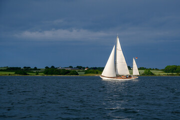 Segelyacht, Ketsch in der Sonne vor dunklen Wolken