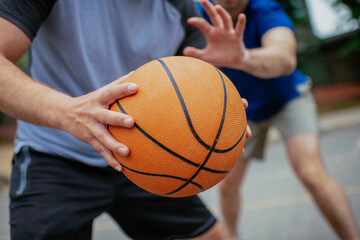 Close up of hands holding ball. Friends playing basketball in the park. - Powered by Adobe