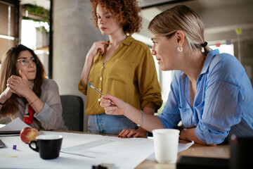Businesswomen working on a new project. Colleagues discussing about problem they have to solved.