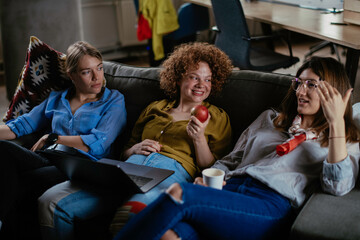 Happy businesswomen talking and laughing in office. Beautiful women on coffee break.