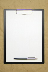 A tablet with a white sheet of A4 format on a beige craft paper.