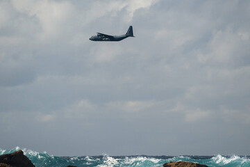  old vintage plane flying low over the beach, fly by