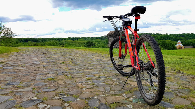 Ukraine, Kiev - June 11, 2020. Beautiful summer natural landscape image with a red mountain bike stands on a rocky road.