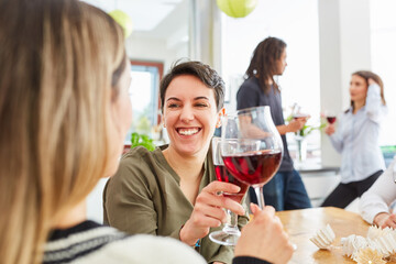 Zwei Frauen als Freunde stoßen mit Rotwein an