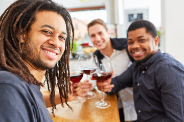 Männer als Freunde trinken zusammen Wein in der Küche