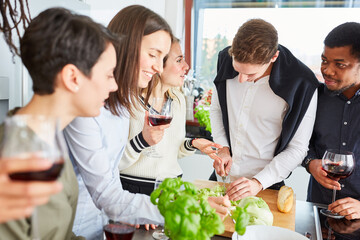 Freunde in Küche bereiten Essen und Salat vor