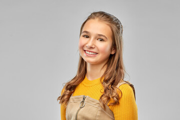 people concept - portrait of smiling teenage girl over grey background