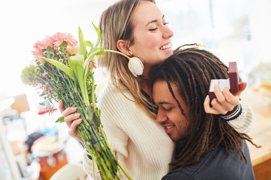 Mann schenkt Frau Schmuck und Blumen zum Valentinstag