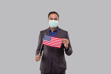 Businessman Holding American Flag Wearing Medical Mask. Indian Businessman Standing Full Length with USA Flag in Hands