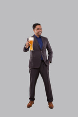Fototapeta premium Businessman Showing Beer Glass. Indian Business man Standing Full Length with Beer in Hand