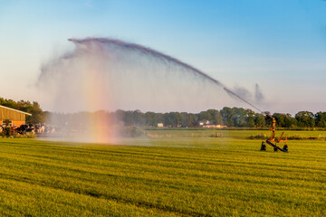 The farmer sprays the grass with water during times of drought in the Netherlands, Friesland province near the village of Harich
