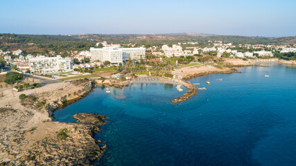 Obraz na płótnie Canvas Aerial bird's eye view of Green bay in Protaras, Paralimni, Famagusta, Cyprus. Famous tourist attraction diving location rocky beach with boats, sunbeds, sea restaurants, water sports from above.